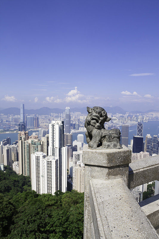 以香港天际线为背景的石狮雕像