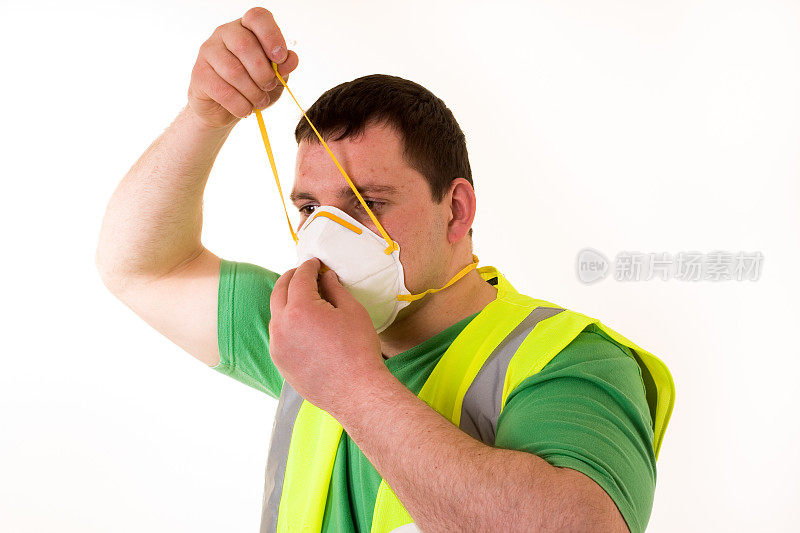 男建筑工人戴着防尘面具