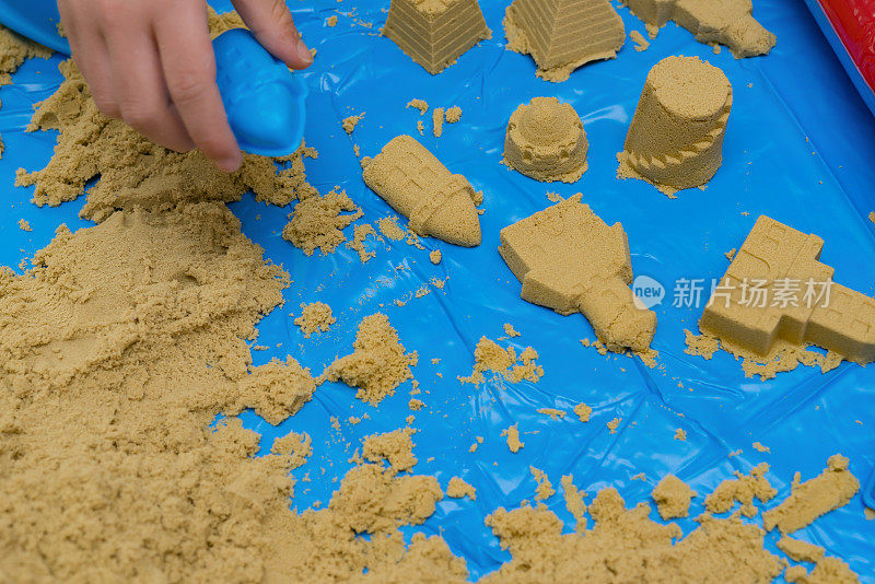 孩子们用砂子和模具做出不同的形状