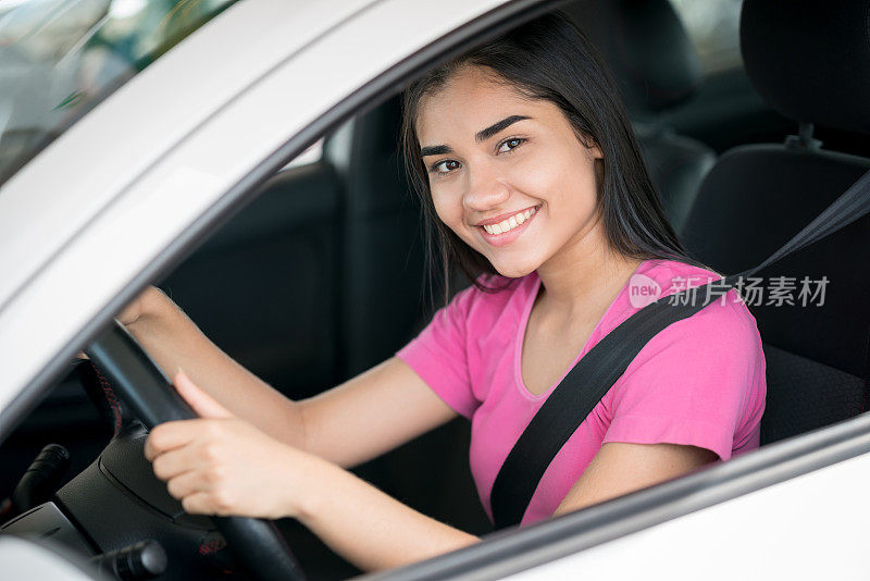 一个快乐的年轻女人开车的肖像