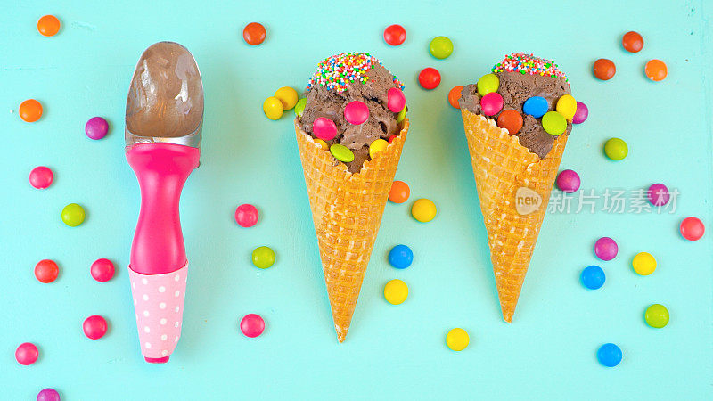 蓝色的木制头顶上，装饰着糖果的巧克力冰淇淋蛋卷
