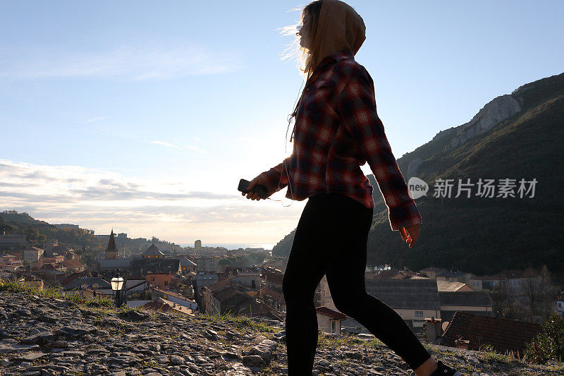 日出时，年轻女子在村庄和海面上行走