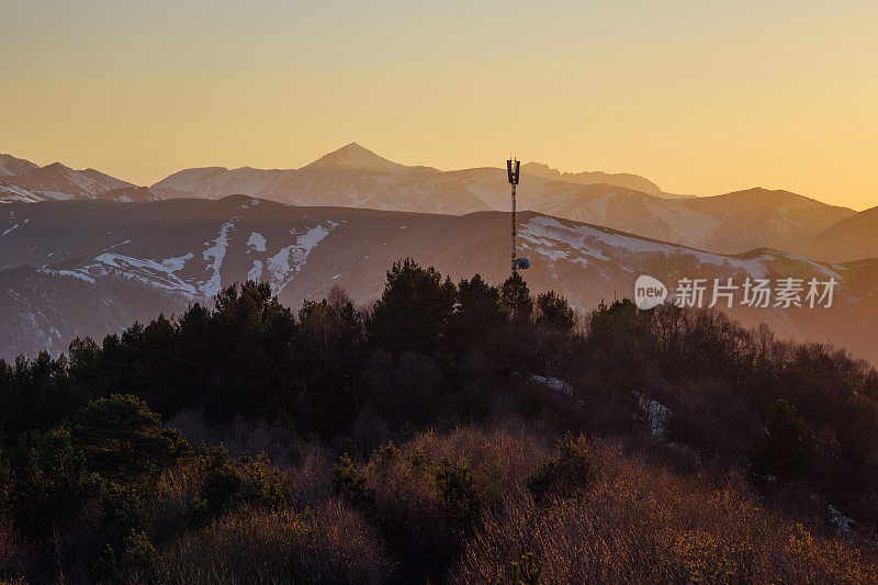 天线，无线电塔背景美丽的傍晚日落在高加索山脉与雪峰，阿尔赫兹，俄罗斯