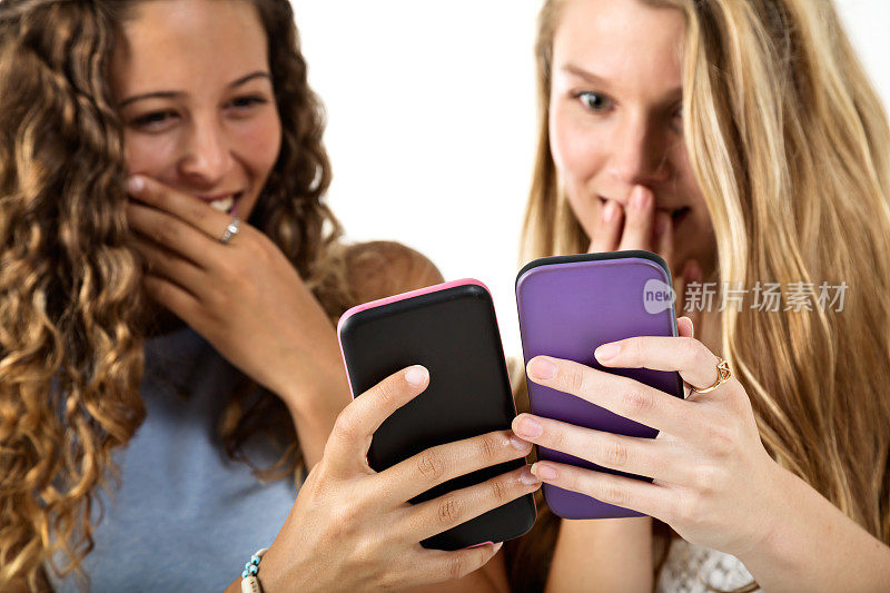 两个漂亮的女孩看着手机屏幕傻笑着，震惊了