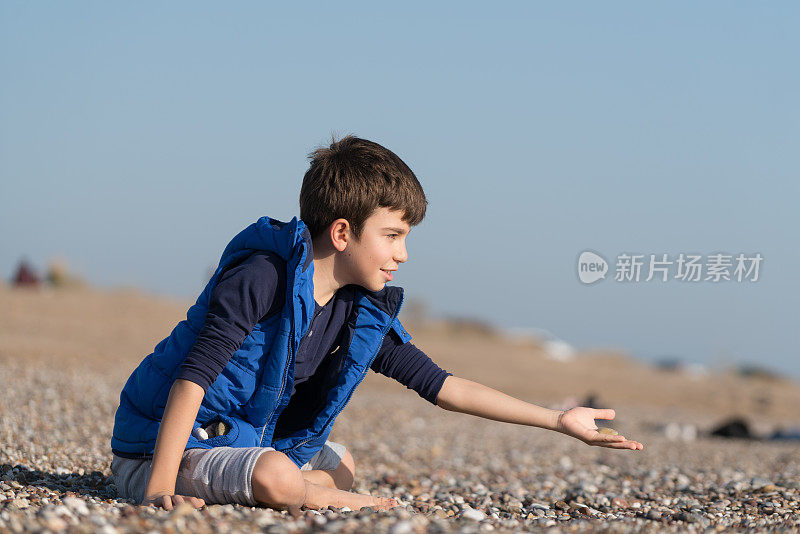 快乐的男孩在一个冬天的一天在沙滩上玩