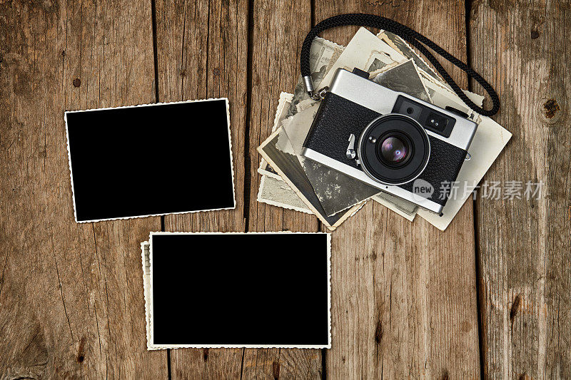 老式胶卷相机，只有几张照片和两个空白的相框一个在木桌上