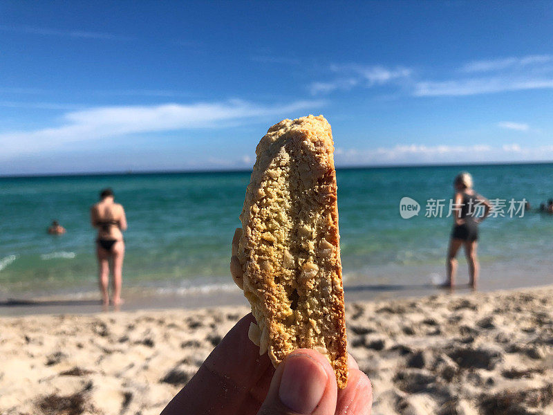 在海滩上牵着Biscotti