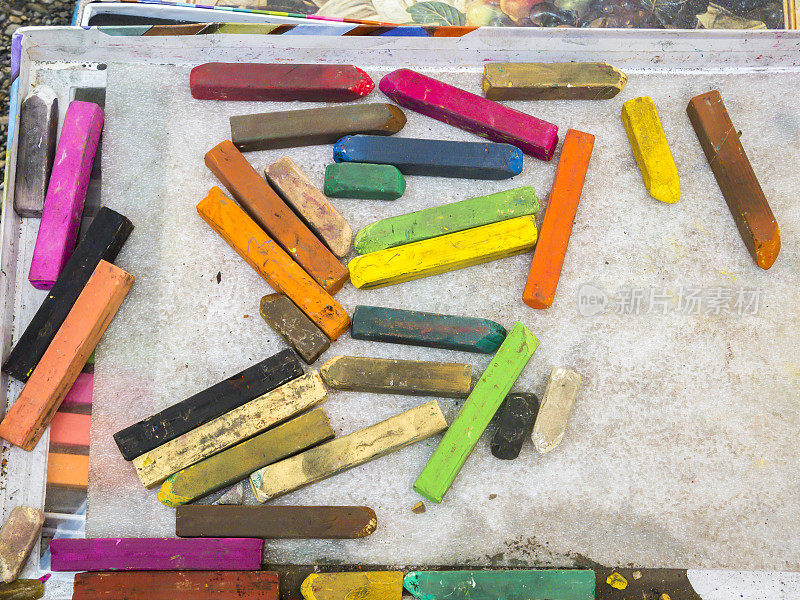 分散的彩色艺术家的粉笔和彩色蜡笔
