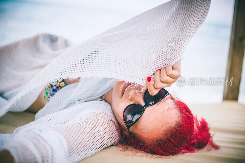 穿着夏装的女人望着天空和大海