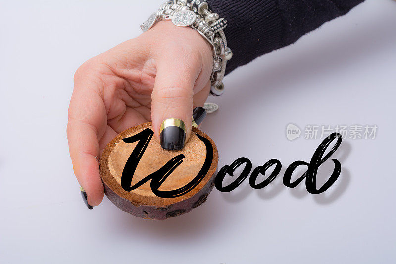 女人的手臂上呈现出一片带有文字的木头