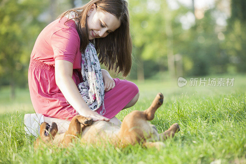 女孩在公园里和狗玩耍