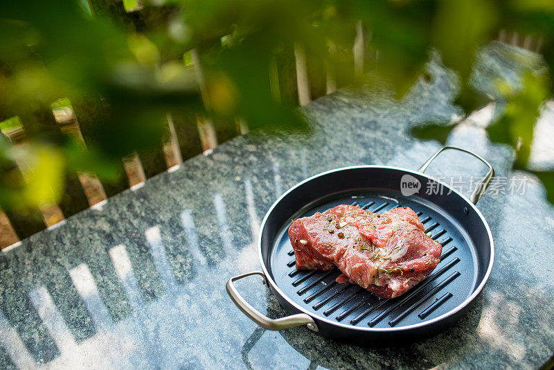 户外桌子上煎锅里的生肉