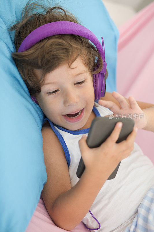 男孩喜欢音乐，拿着智能手机