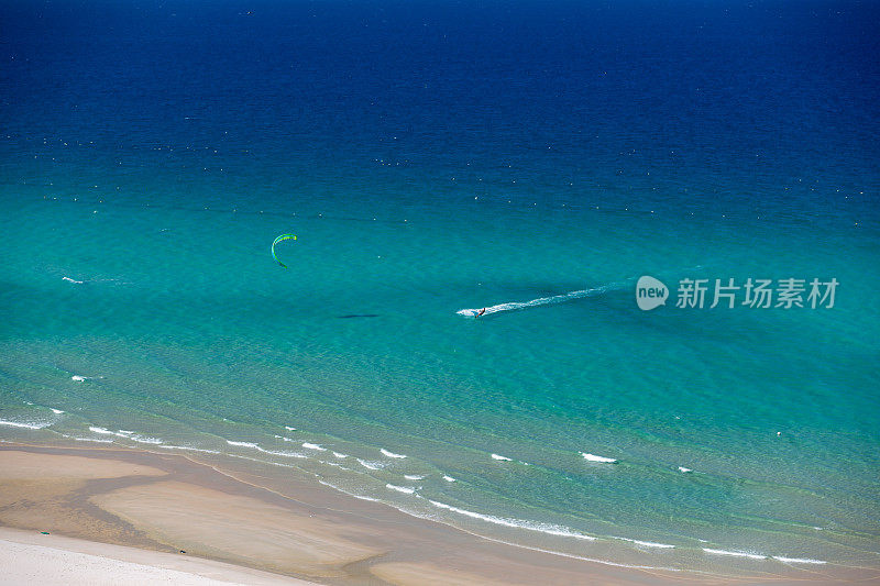 风筝冲浪在热带碧水海滩上从空中鸟瞰拍摄的照片