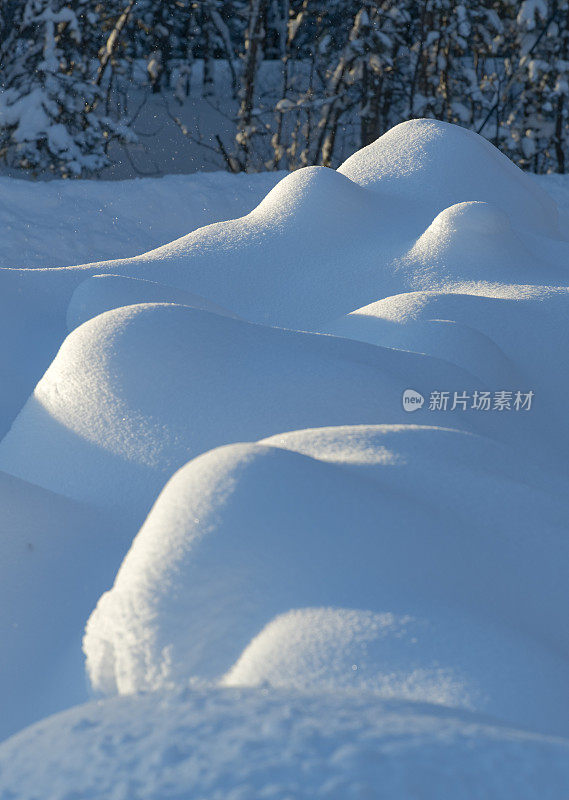 暴风雪过后，小雪堆在阳光下的小山