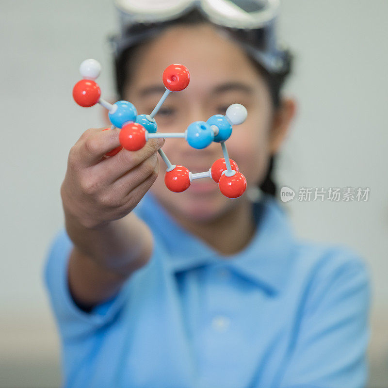 初中女孩享受STEM科学课和炫耀分子模型