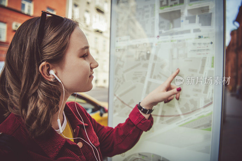 少女探索城市地图在夏天的街道上旅行