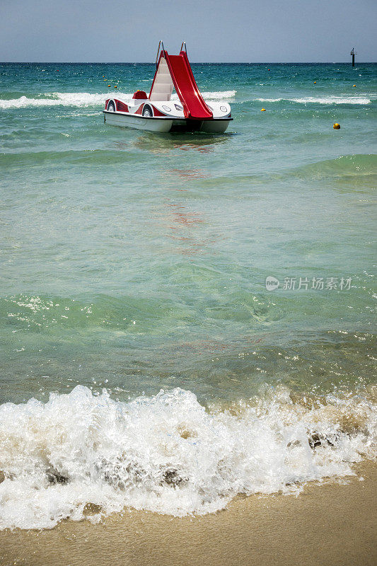希腊哈尔基迪基海滩上，一艘带滑水道的脚踏船