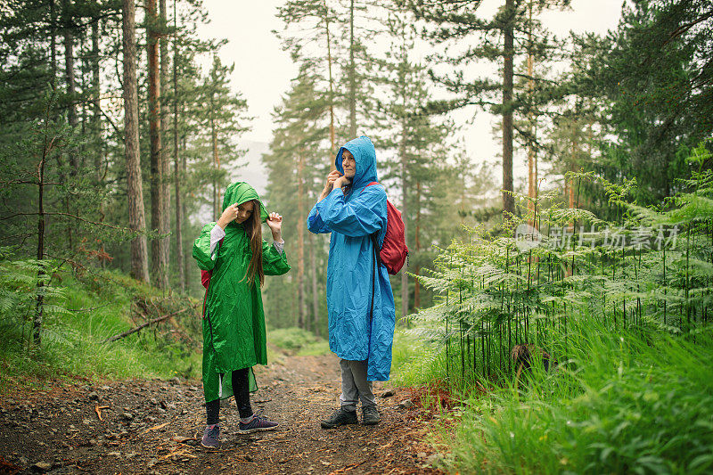 妈妈和女儿在雨中徒步旅行