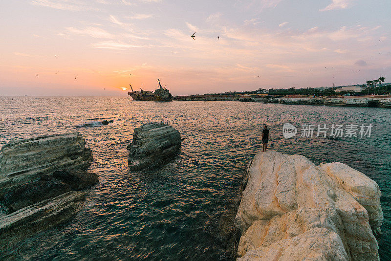 人们看着海边的风景和塞浦路斯的沉船