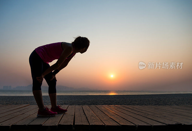 海滩上疲惫的跑步者的剪影