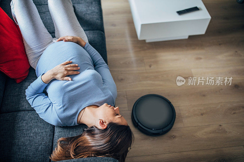 孕妇休息时，机器人真空吸尘器打扫地板
