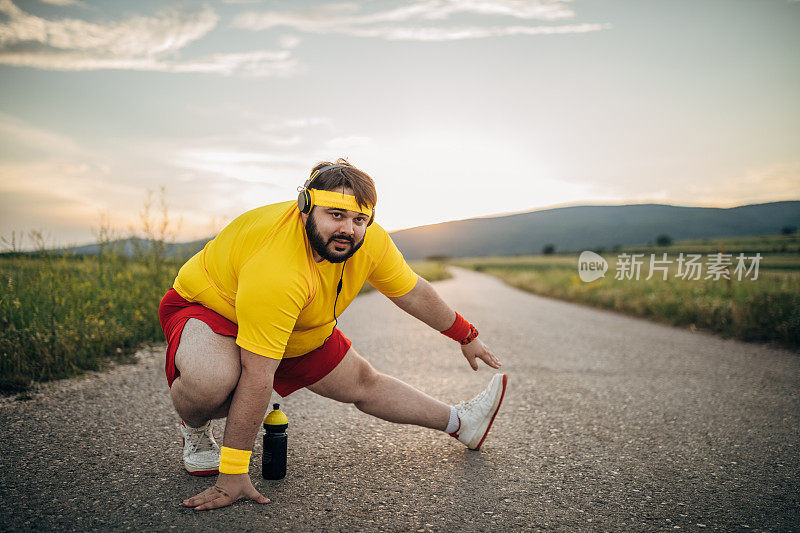 大个子男子在街上慢跑前热身