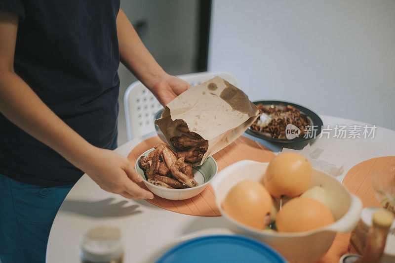 一位亚洲华人中年妇女从外卖点了一份外卖，然后准备回家吃午饭