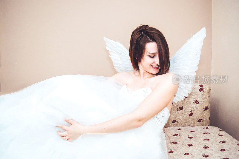 美丽的天使在一个白色连衣裙库存照片
