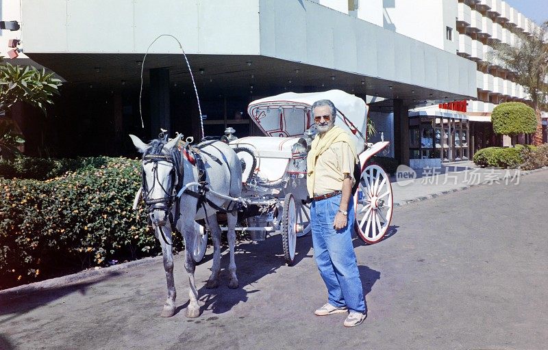 年代。一名游客正在寻找马车车夫。卢克索,上埃及。