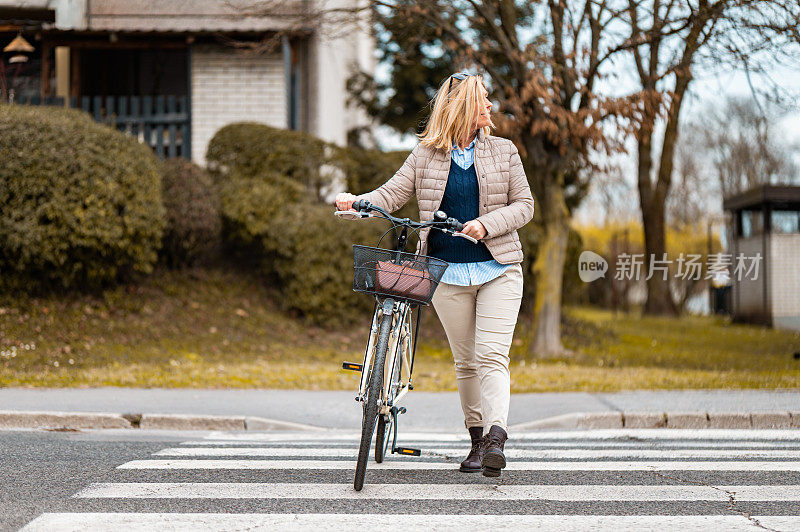 一个骑着自行车过马路的女人