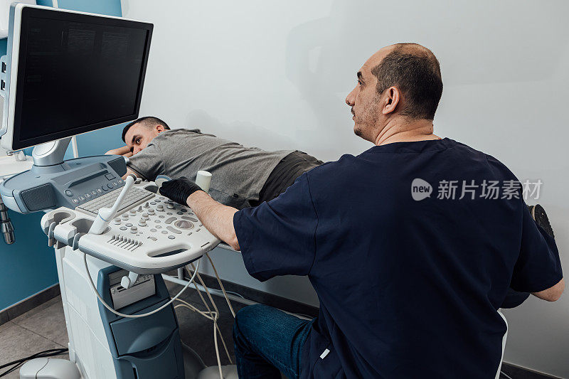 医生正在对躺在担架上的病人进行超声波扫描