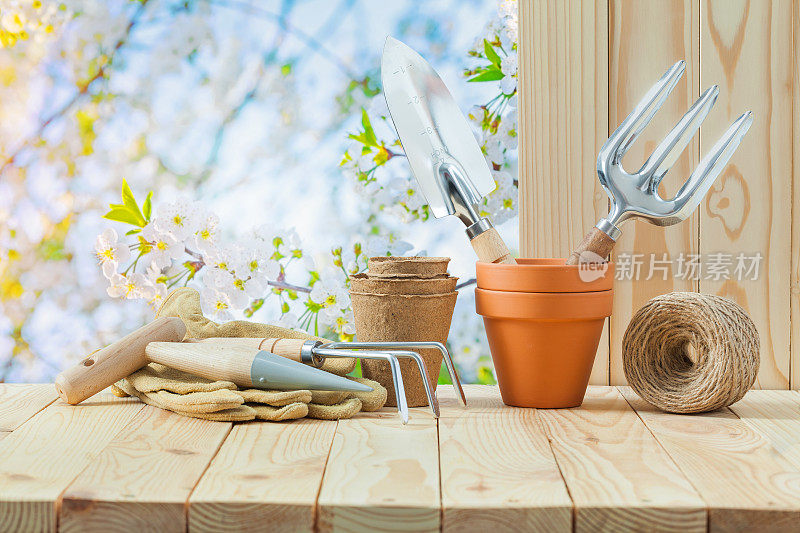 园艺工具放在花园里的木桌上