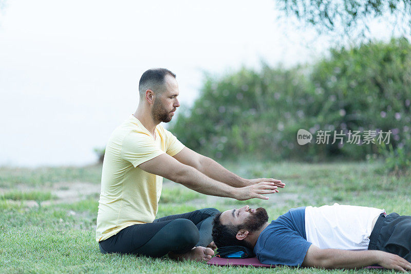 一个男人在给她的病人做瑜伽治疗