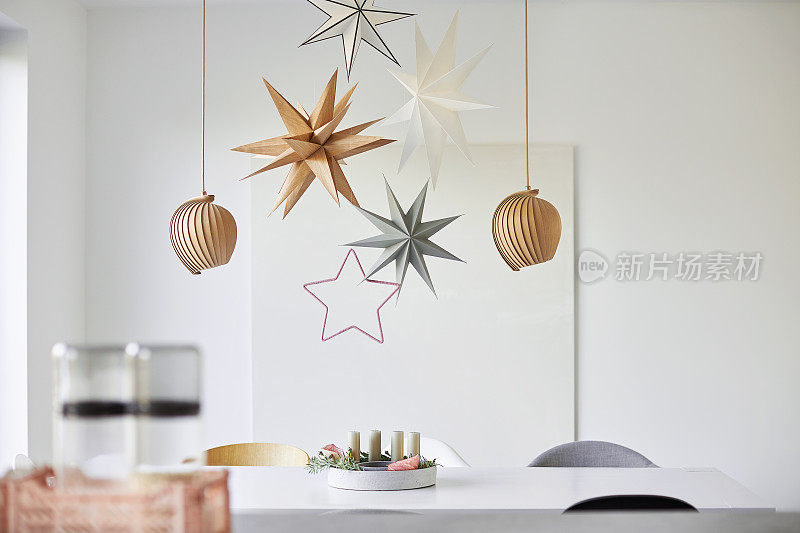 一个现代而简单设计的圣诞餐桌装饰，用高分辨率拍摄的圣诞花环，星星和鲜花