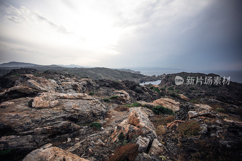 不真实的风景。岩石海岸上的穆迪天空。