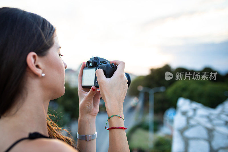 一个年轻的女人在改变她的相机设置