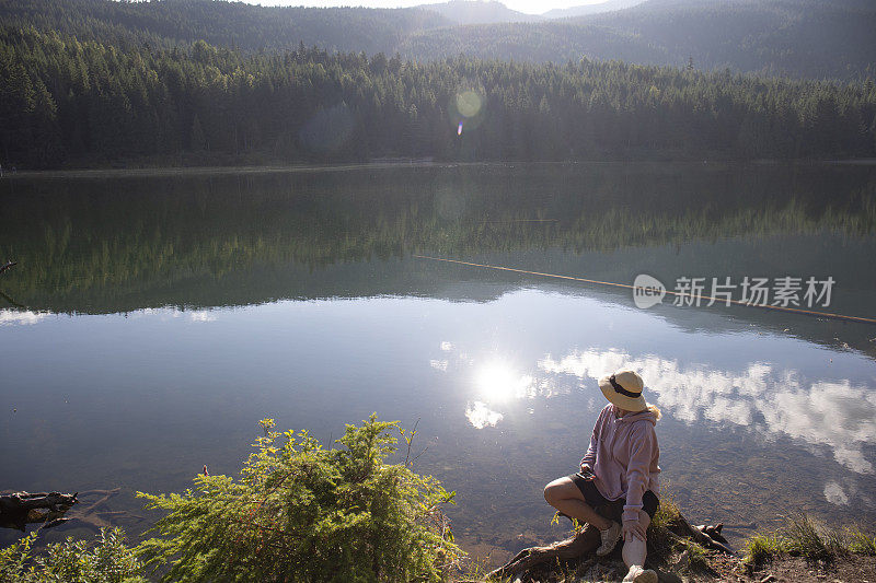 成熟的女人早晨在湖边放松