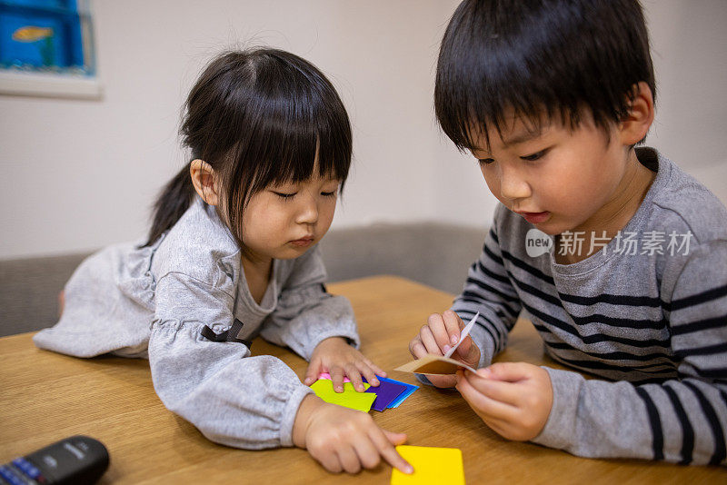 小儿子和女儿在餐厅里制作折纸工艺