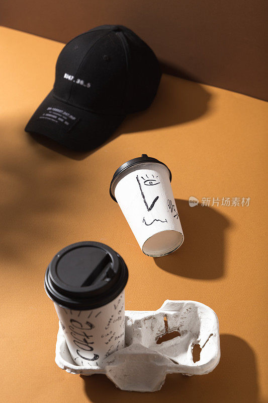 咖啡杯。新鲜美味的咖啡在白色的纸杯与打印在棕色的背景