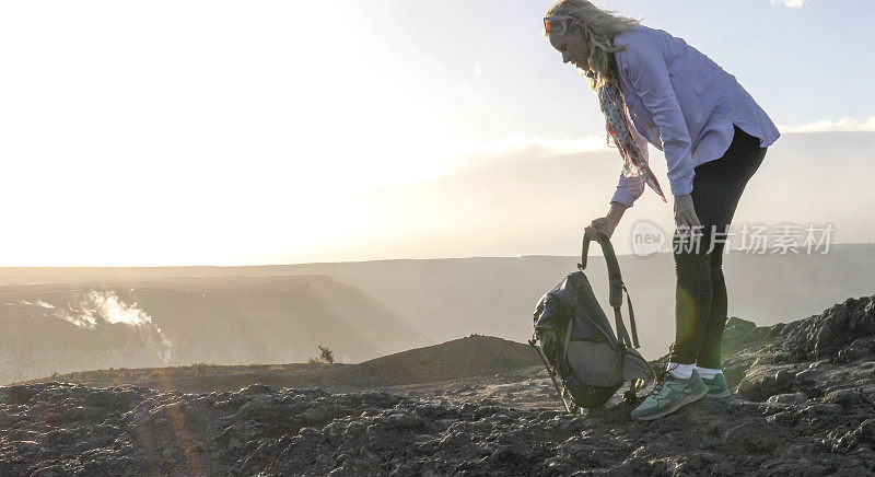 徒步旅行者探索坑边缘小径，Kīlauea的火山口