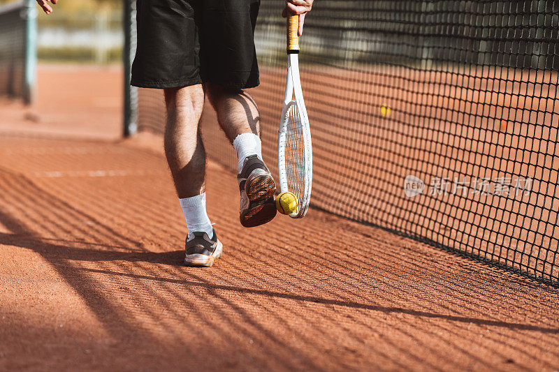男网球运动员展示用脚和球拍捡球的技术