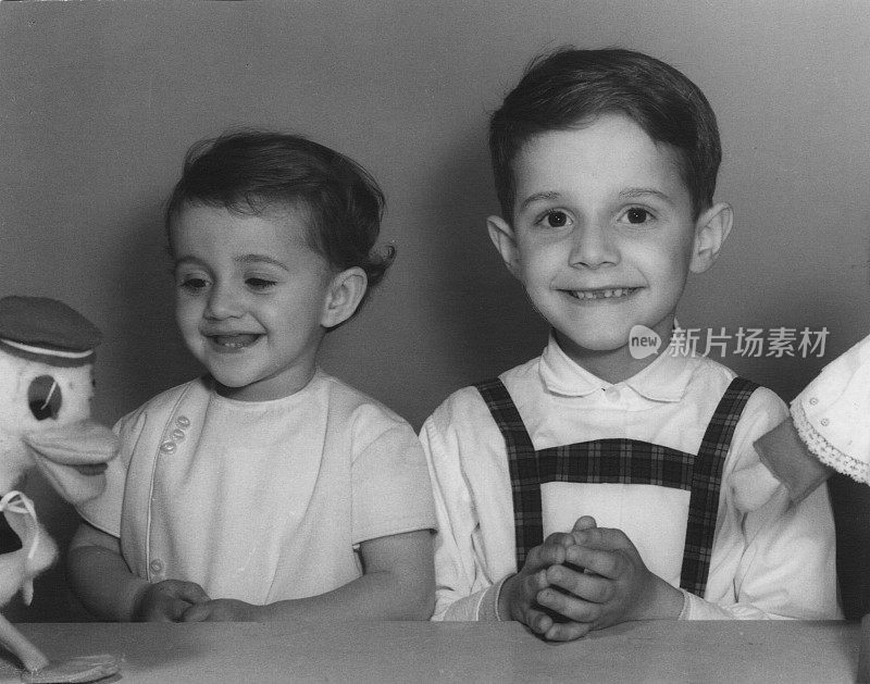 60年代的经典照片，一个小男孩和一个小女孩微笑着摆姿势