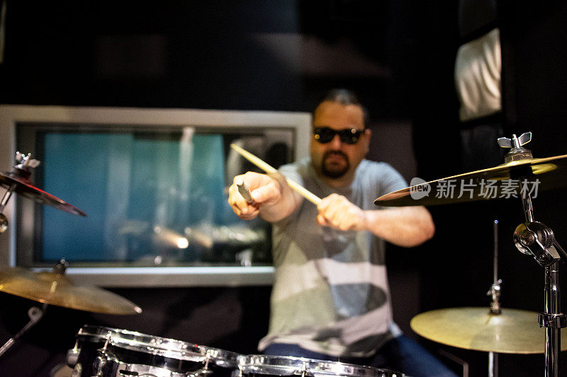一名男子在音乐工作室练习电子鼓