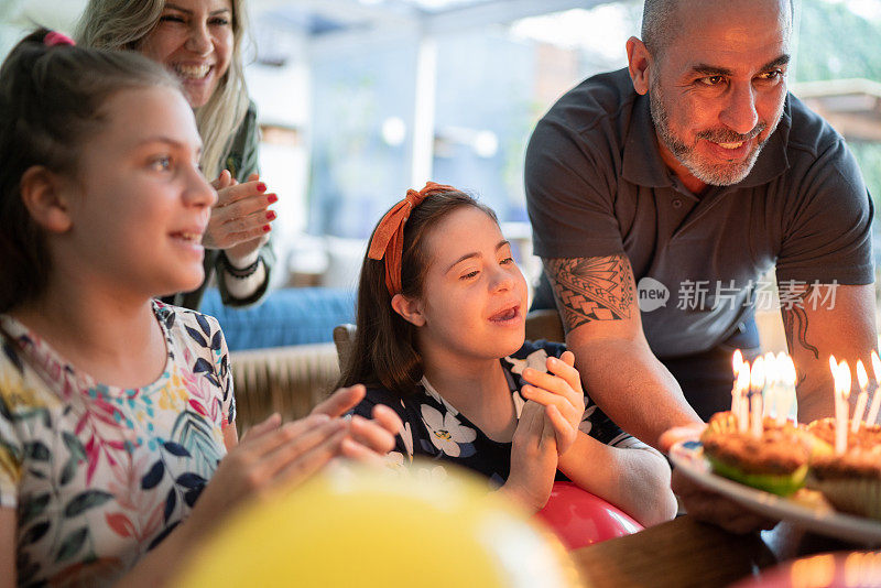 一个家庭在家庆祝女儿的生日——包括一个特殊需要的女孩