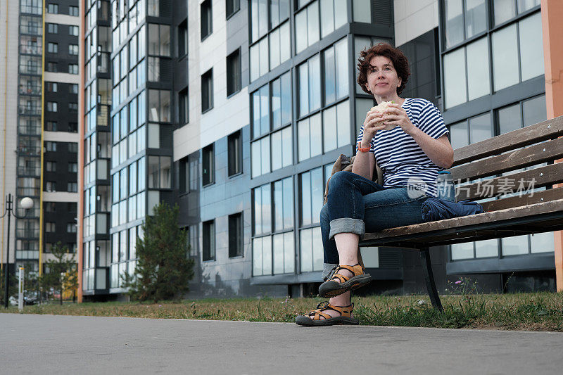 一个女人在城市的长椅上休息