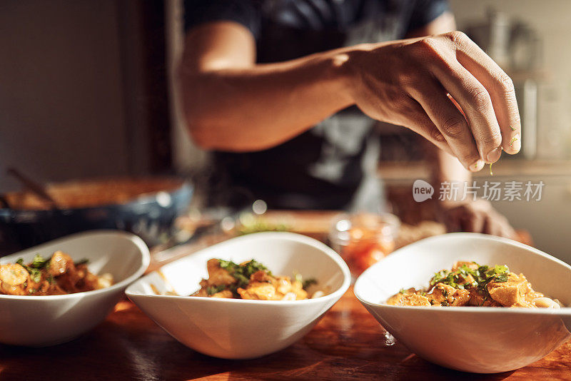 照片中，一个面目全非的男人正在家里准备美味的饭菜