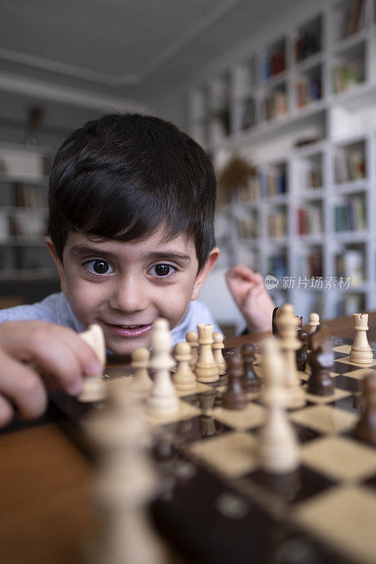 父亲和儿子一起在家里下棋。家人在家里。