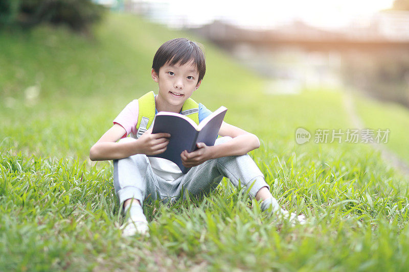 小男孩背着书包走回学校