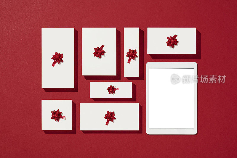 数字平板模型，模板上的圣诞节概念红色背景与白色礼品盒